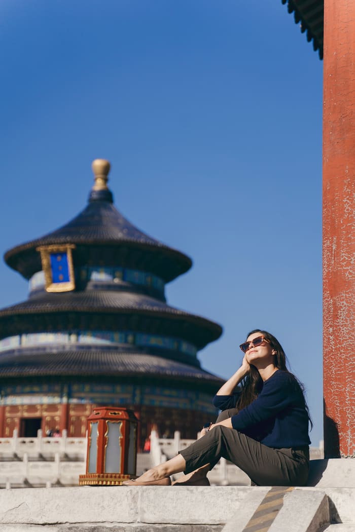 Mujer sentada posando en beijing de fondo un templo